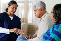 caregiver giving medicine to senior